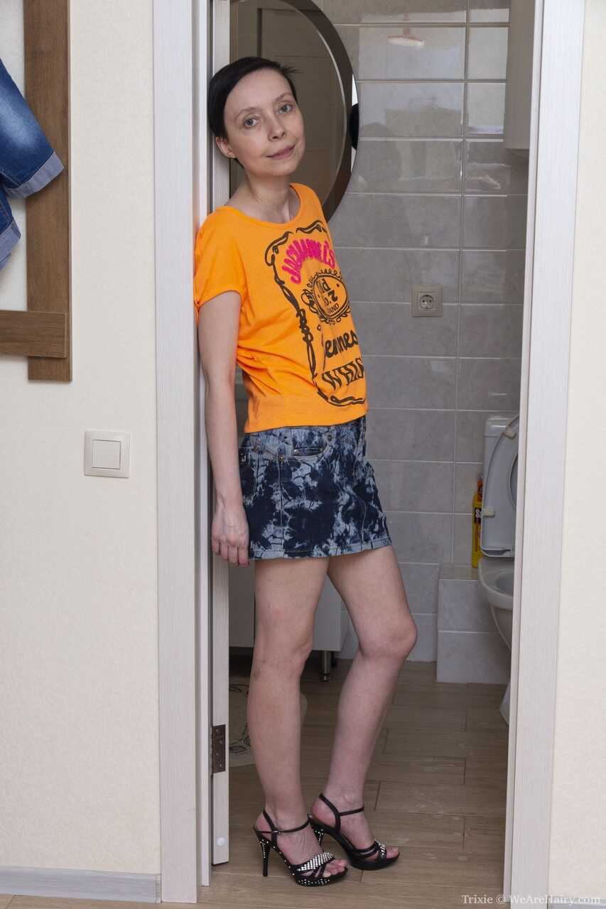 Petite mature woman Trixie strips & washes her bush in the bathtub - Trixie