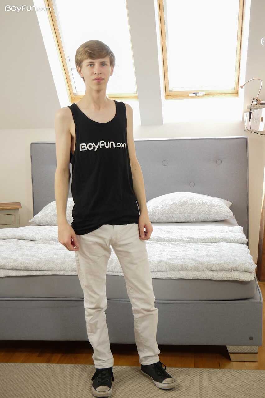 Slim gay Gabe Isaac's big cock takes center stage as he poses naked in his bedroom