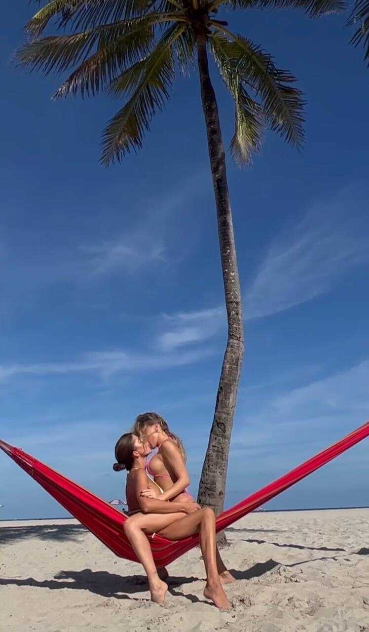 Making out with your sexy girlfriend on the beach while wearing a bikini top and skintight jean shorts - 