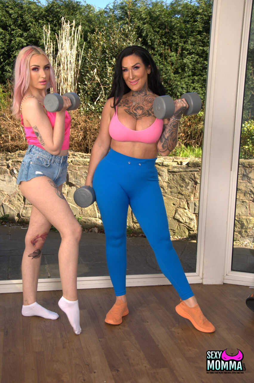 Inked stepmom Ella Bella strips teen Kitty Marie & toys her pussy with her tattooed body and mom feet while wearing he...