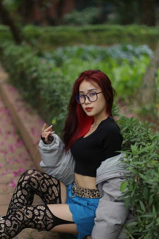 Natalia, the sexy nerd Asian babe with glasses and red stockings in the garden