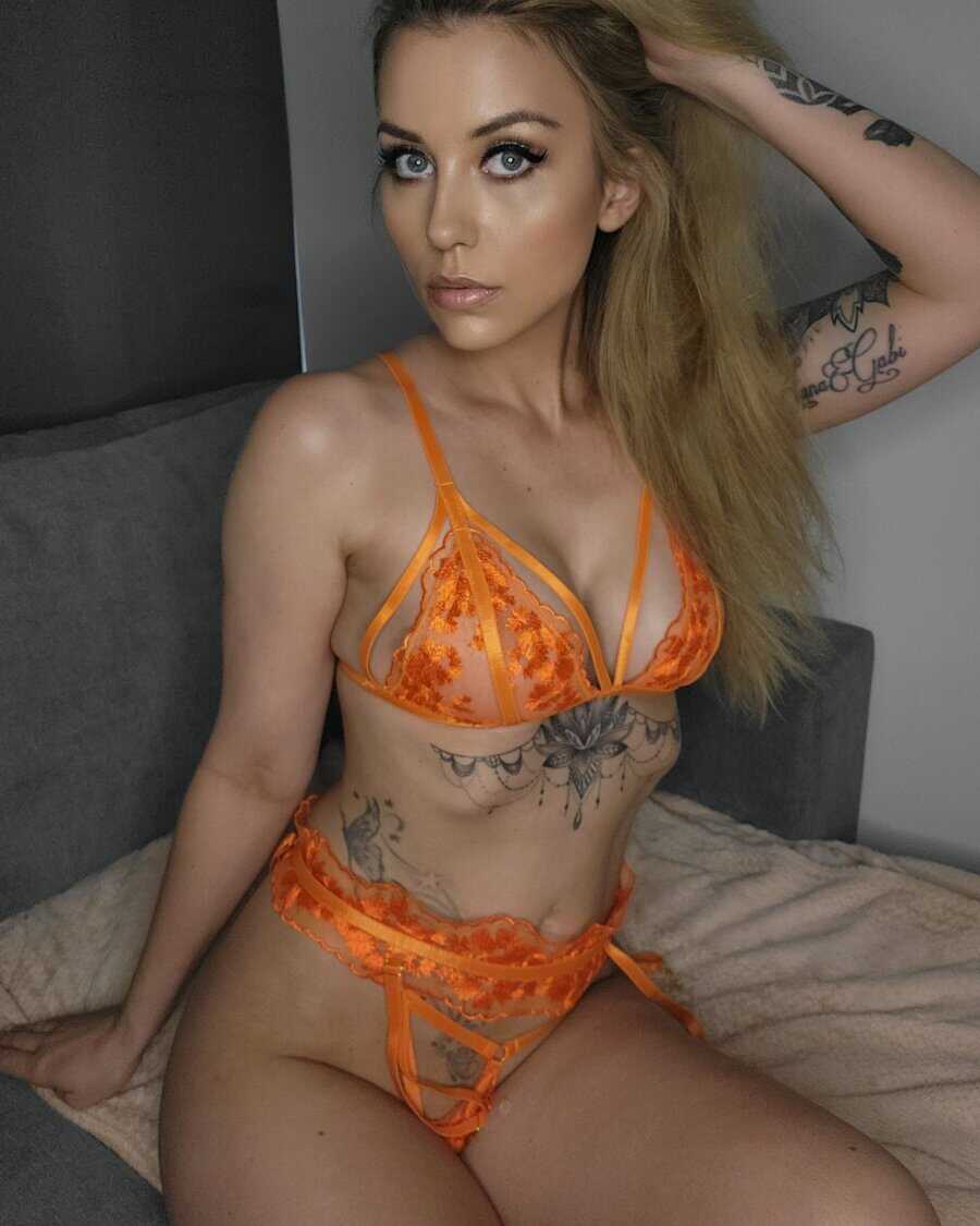 Sexy blonde teen babe with a big ass and gorgeous tattoos seduces you in her lacy lingerie .