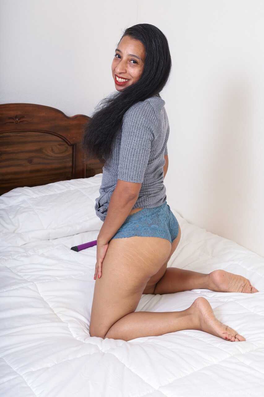 Long haired amateur Divine flaunts her small tits and bushy beaver on a bed with her hairy skinny mature body - Divine