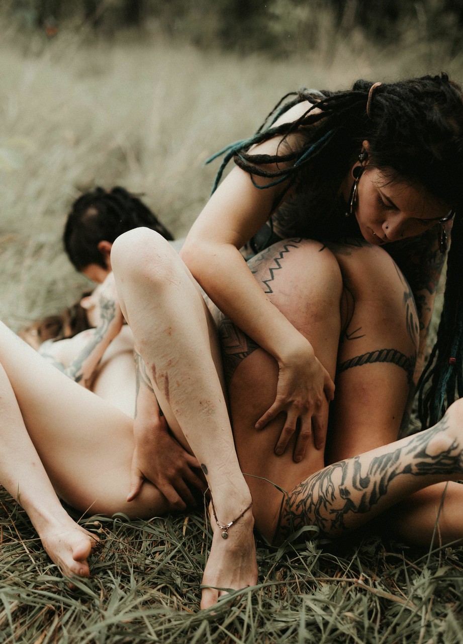 Three Tattooed Girls Share Lesbian Kisses In Long Grass Near A Fir Tree