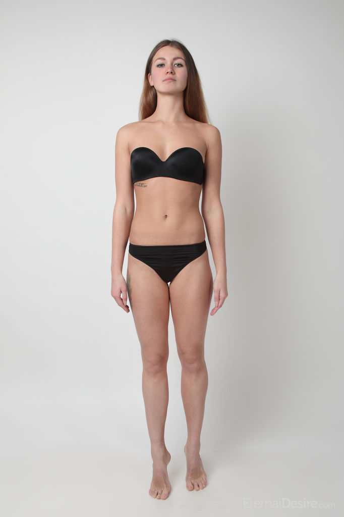 若いスリムな少女ソルヴェイグがブラとパンティーを脱いで裸で立っている