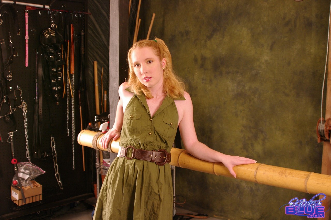 الشقراء الحمراء نيكي بلو مقيدة إلى قضيب الخيزران من المعصمين والرقبة