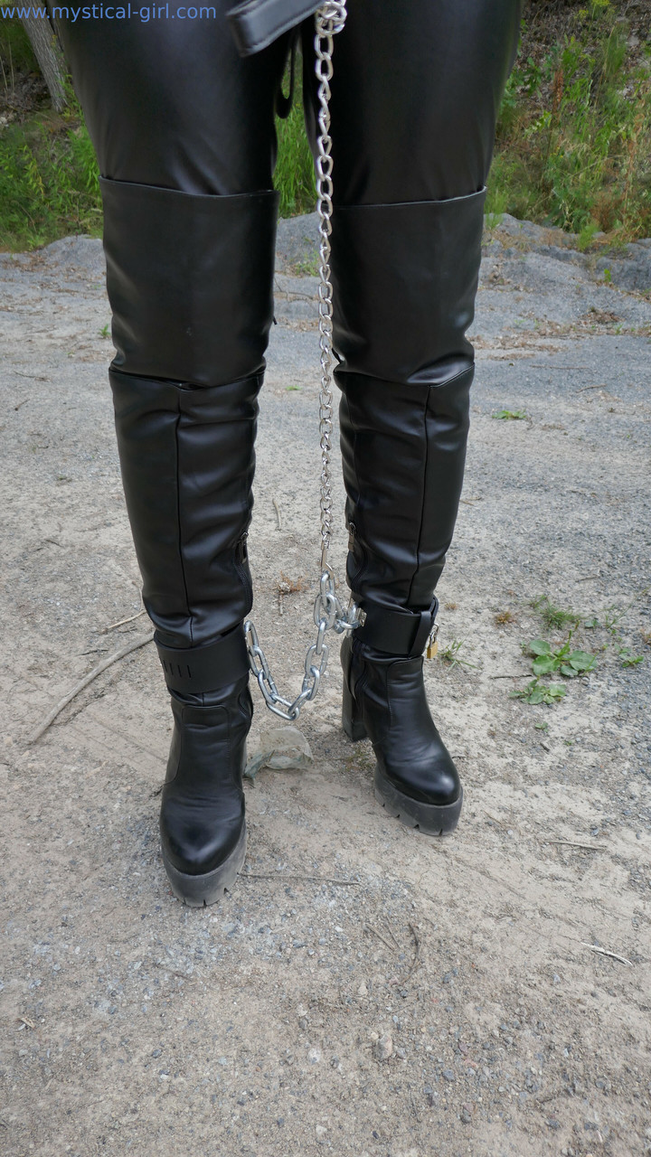 革の手錠と鎖で拘束された首輪の女性