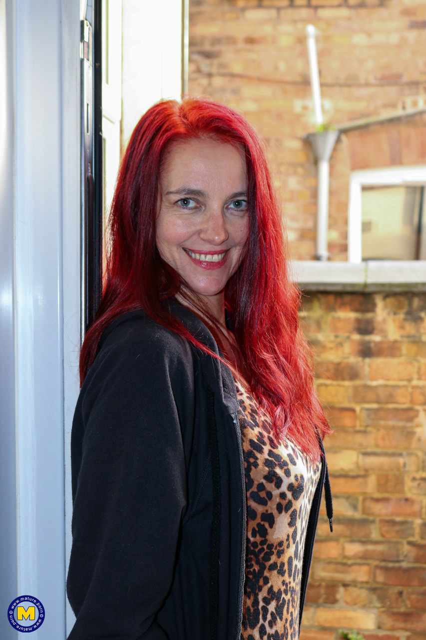 امرأة ناضجة حمراء الشعر كاتيي تخلع ملابسها حتى الكعب وتفرش فرجها