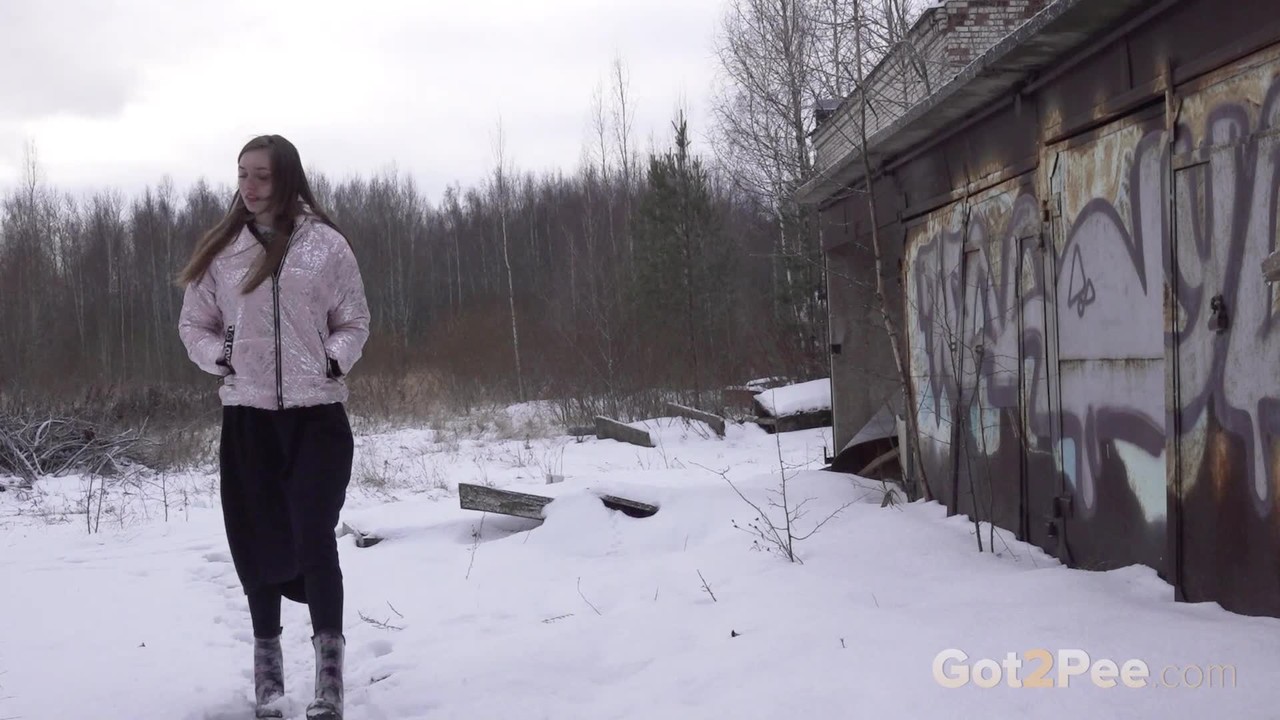 廃墟のテーブルで困った少女が小便する