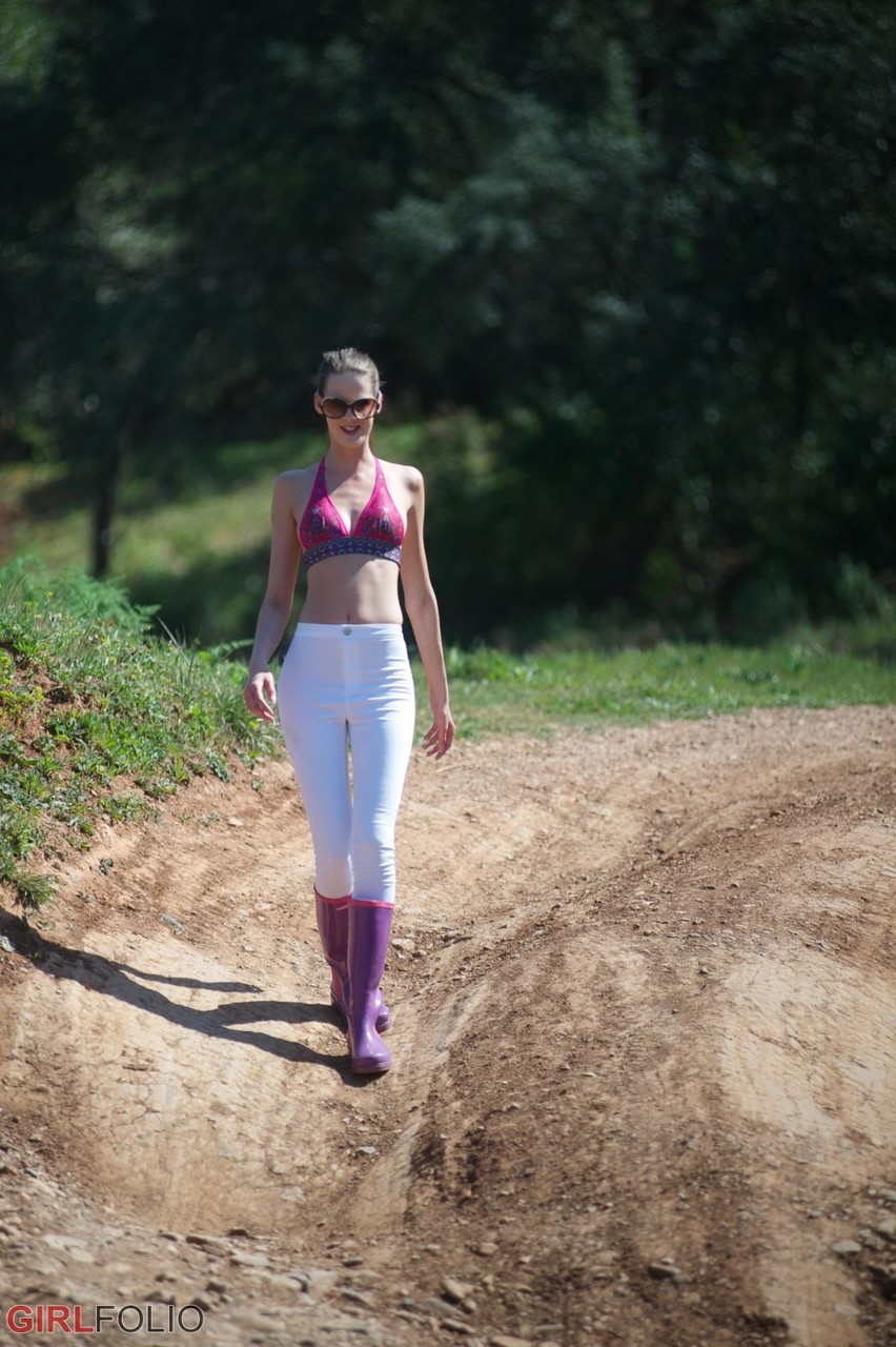 Thin Solo Model Melissa Tongue Strips To Her Rubber Boots In Stream