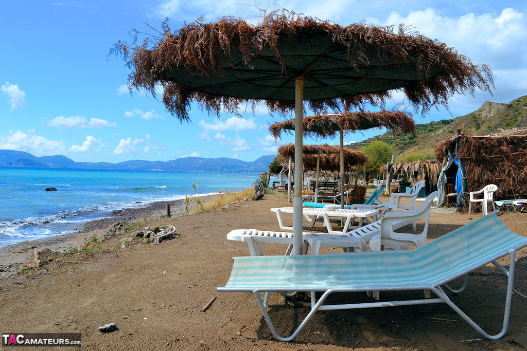 Femme Blonde Pulpeuse Aux Gros Seins Se Promène Sur Une Plage Nue Avec Un Chapeau De Paille