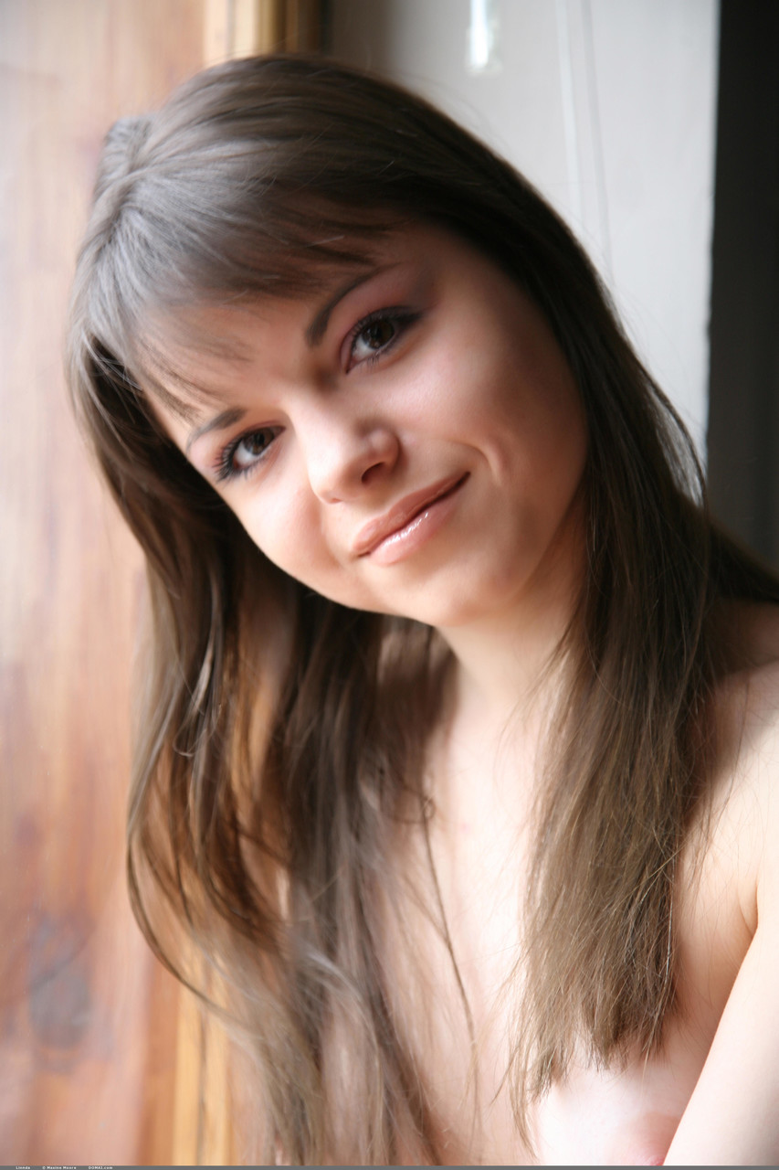 عارضة الأزياء العارية الجميلة ليندا تتعرى بجانب النافذة