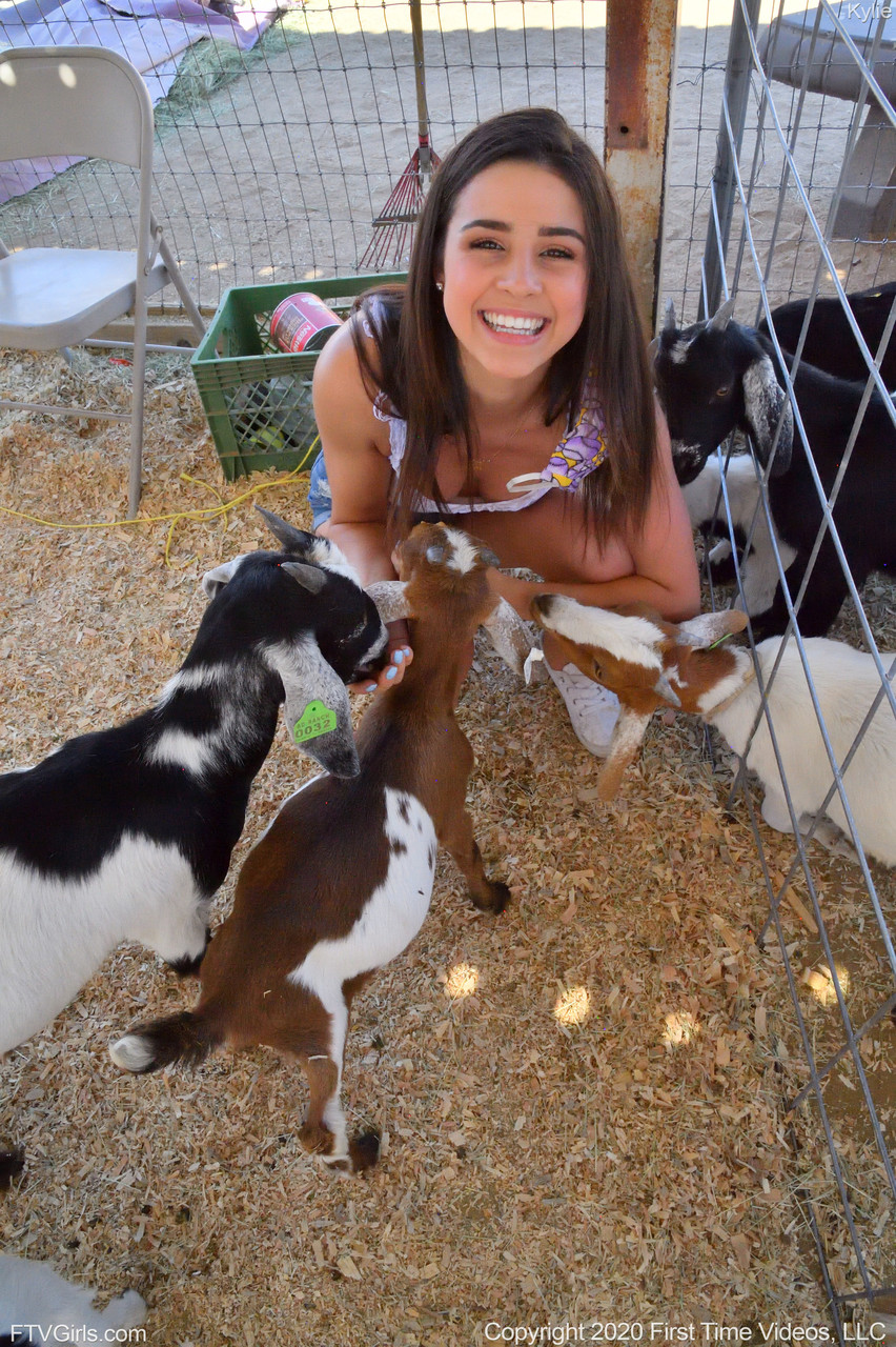 微笑业余宝贝凯莉穿牛仔短裤和白衬衫在动物园摆姿势