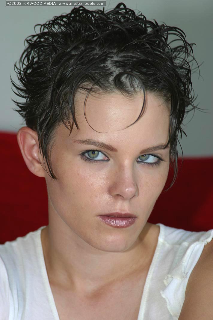 छोटे बालों वाली पहली बार नंगी होकर लाल सोफे पर पहली न्यूड पोज़ देती है