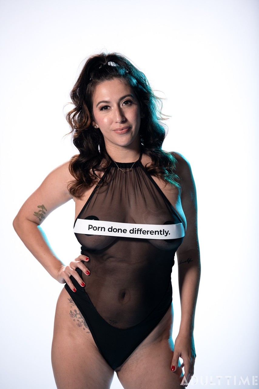 काले बालों वाली अमेरिकी एप्रिल ओ'नील पारदर्शी बॉडीसूट उतारकर अपने वक्र दिखाती है