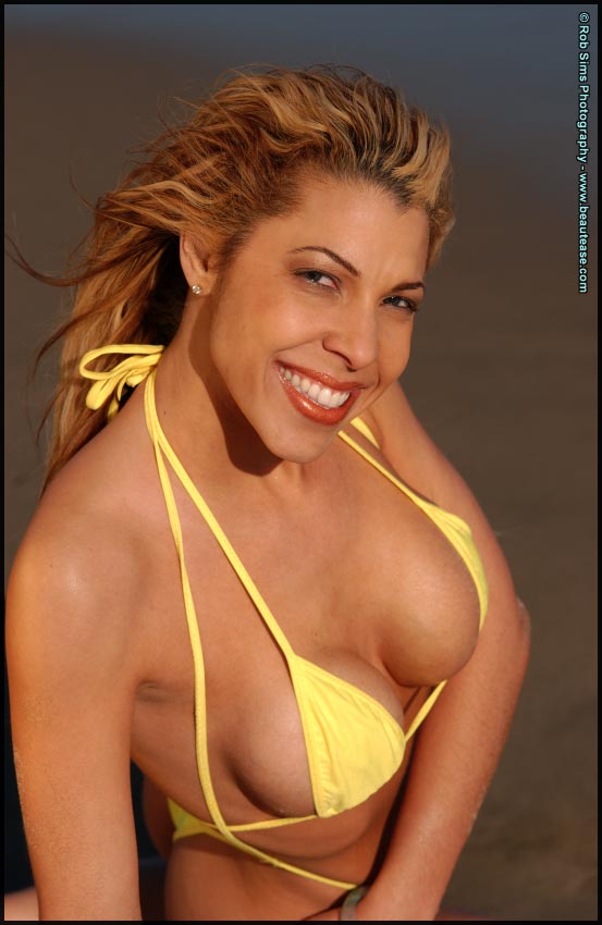 الأم الجميلة جيني لي تُظهر الحلمة في تصوير ملابس السباحة على الشاطئ