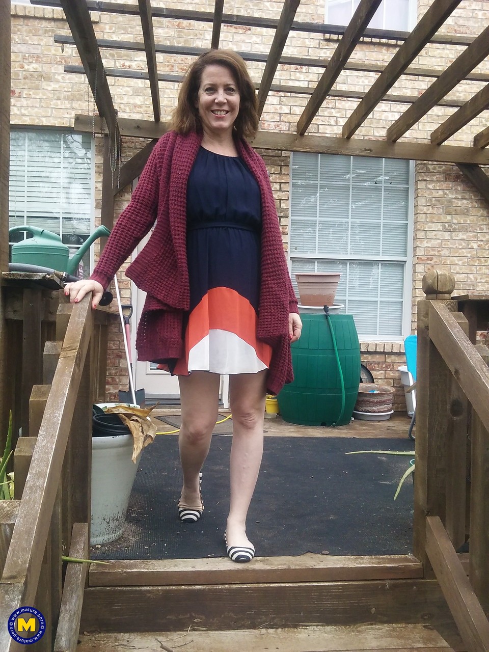 बस्टी परिपक्व महिला ब्री अपने गंजे बुर को बगीचे में खेलती है