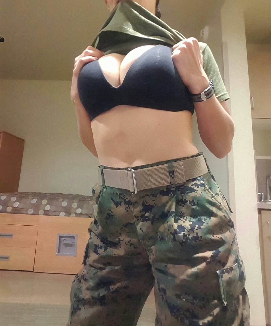 La Femme Militaire Avec De Gros Nichons Se Déshabille Et Pose Seule