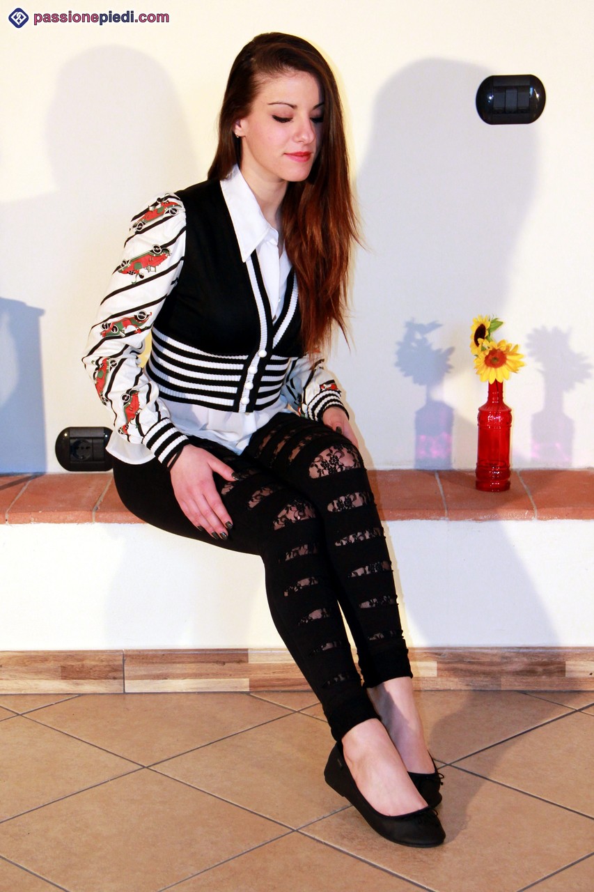 الفتاة الجميلة تخلع أحذيتها المسطحة وتثني أصابع قدميها الجميلة