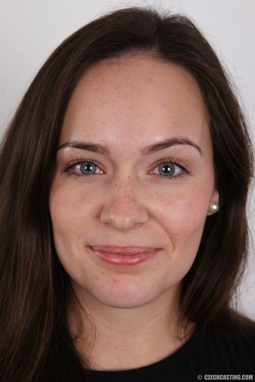 सुंदर भूरी बालों वाली जींस में धीरे-धीरे फोटो के लिए स्टीमी स्ट्रिपटीज़ करती है