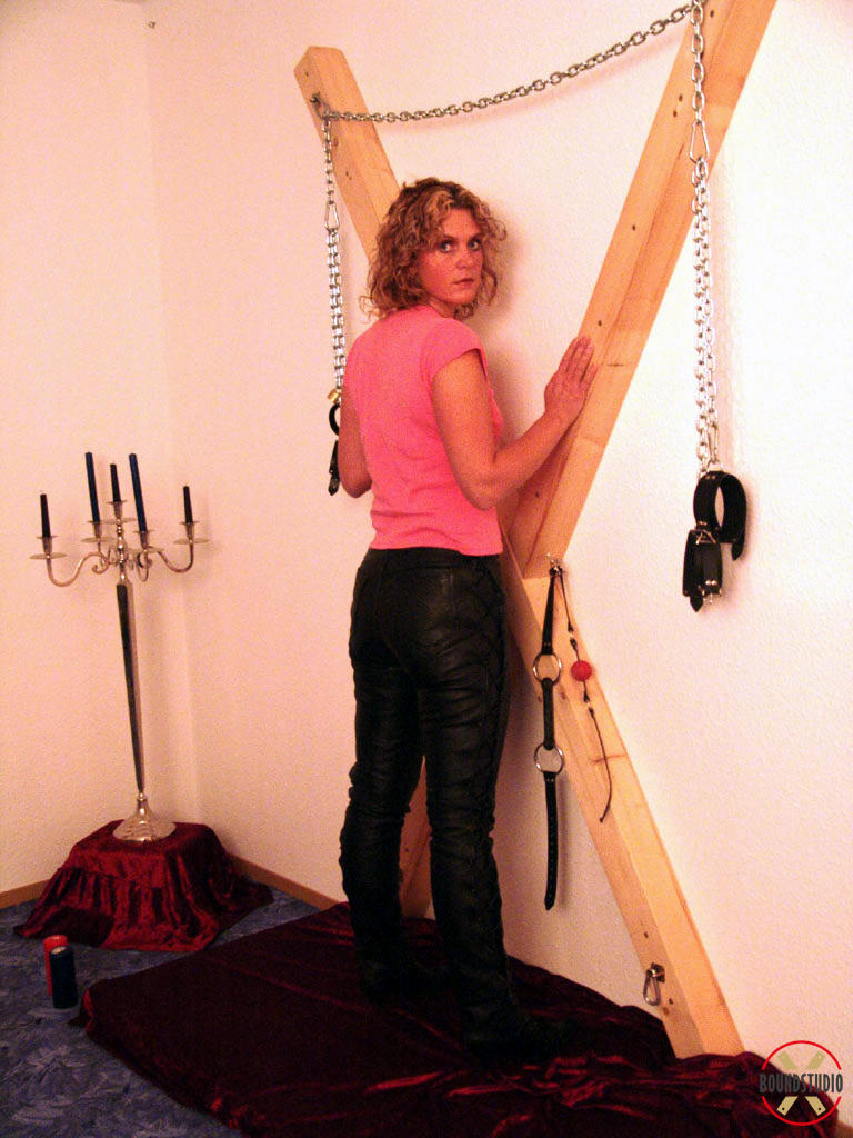 金发莉亚穿衣被束缚在圣安德鲁十字架上