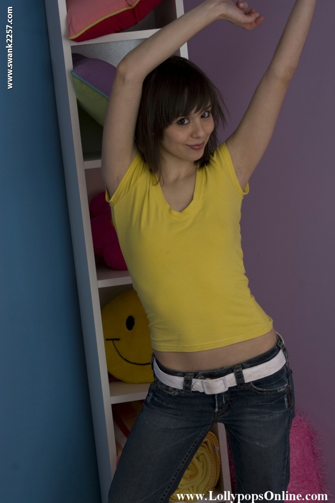 小柄な美熟女アリエル・レベルが黄色のシャツとタイトなジーンズでポーズ