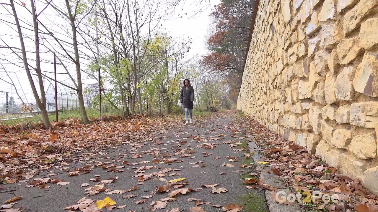 كلوديا ماك تتبول على الأوراق المتساقطة قرب المنتزه الرياضي