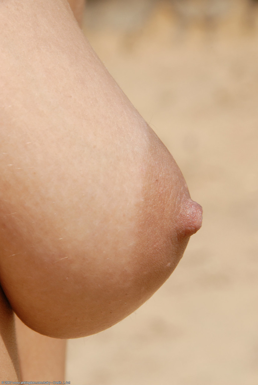 شابة عارية ستاني تظهر مهبل毛ة من قريب على شاطئ رمل