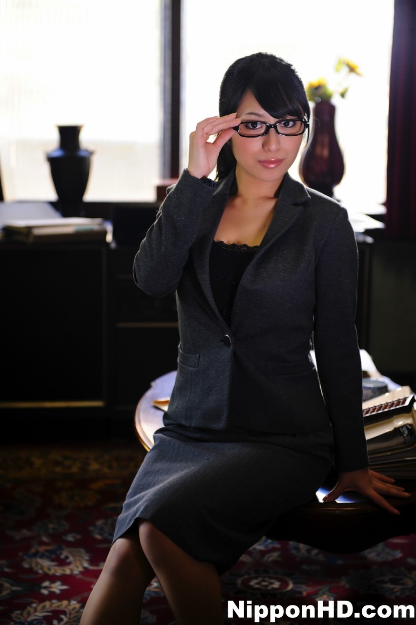 जापानी लड़की पूरी तरह से कपड़े पहने हुए चश्मा उतारती है और फिर से पहनती है