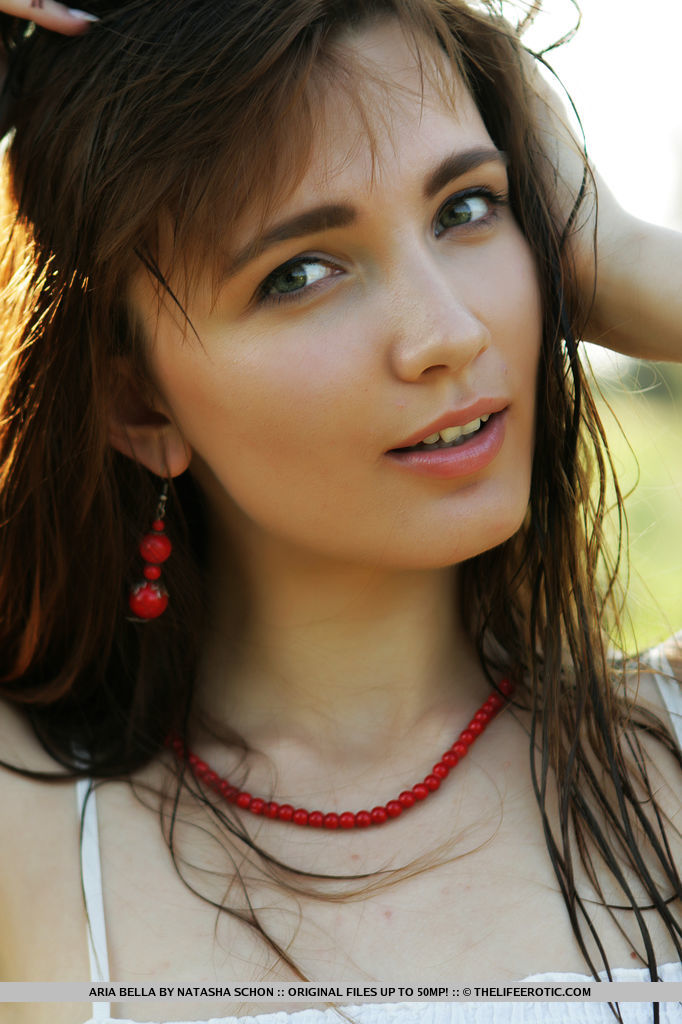 裸の十代の少女は美しい顔で森の中で日光を浴びる