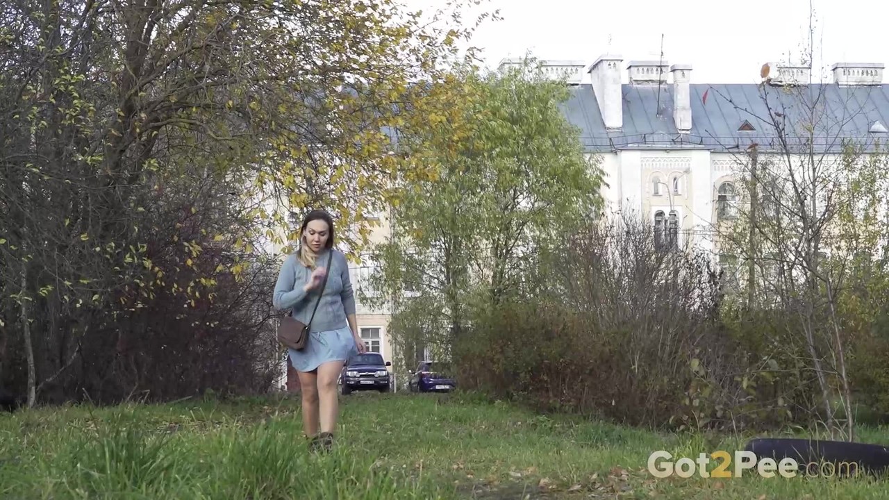 सफेद लड़की डायना घास पर पेशाब करने से पहले झाड़ियों के पीछे छिपती है