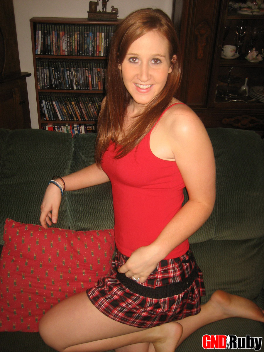 شابة حمراء الشعر تحسس ثدييها الطبيعيين وفرجها على الأريكة