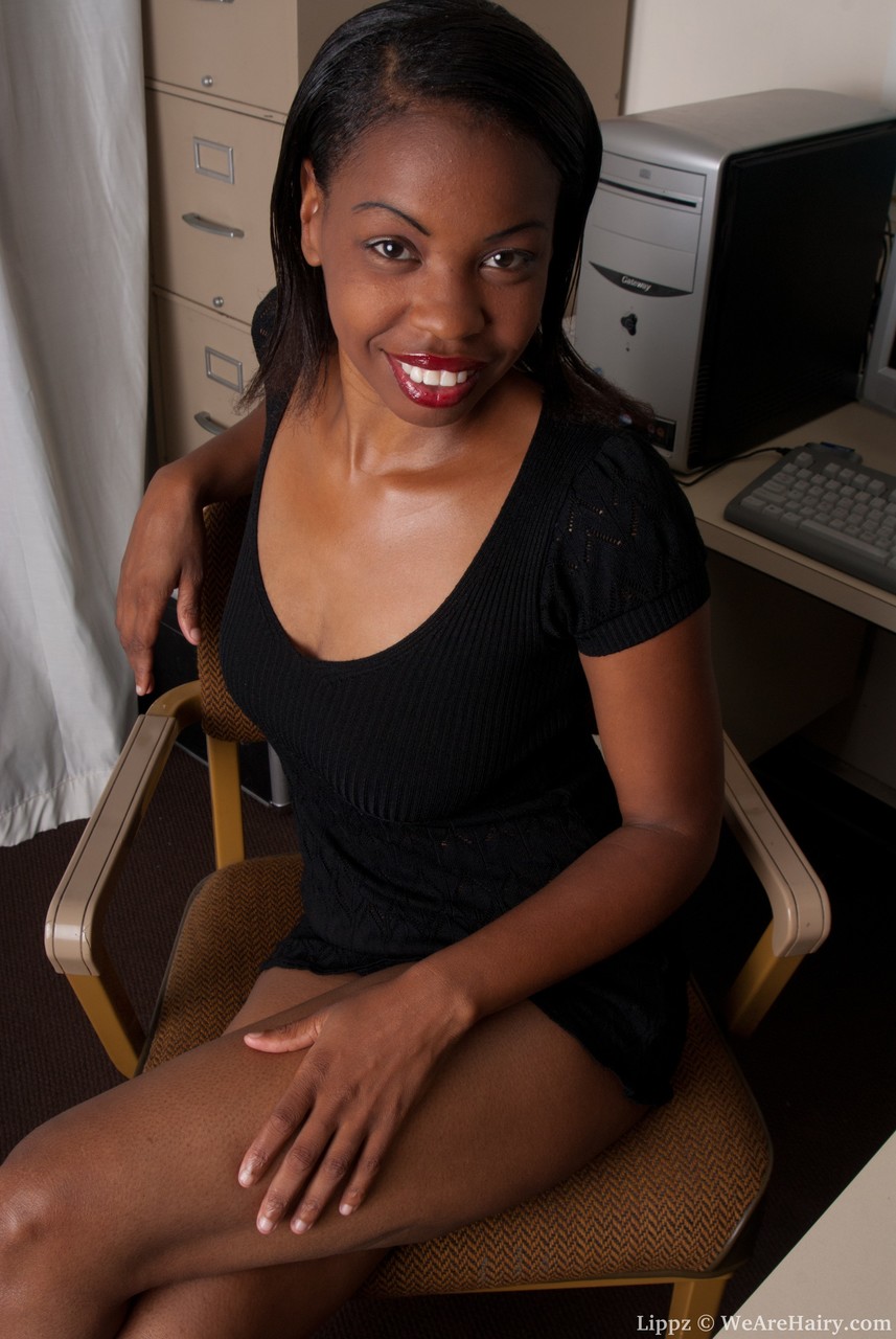 सुंदर चॉकलेट रंग की लड़की लिप्ज़ गर्व से अपनी छंटी हुई झाड़ी प्रदर्शित करती है