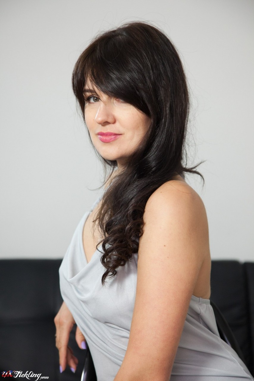 黑发秘书娜塔莎脱下黑色高跟鞋后展示穿袜双脚