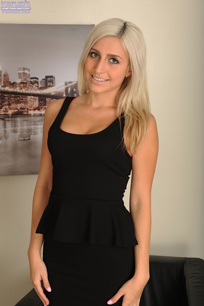 إلهة شقراء Xandra Sixx واقفة في فستان أسود وتظهر فرجها