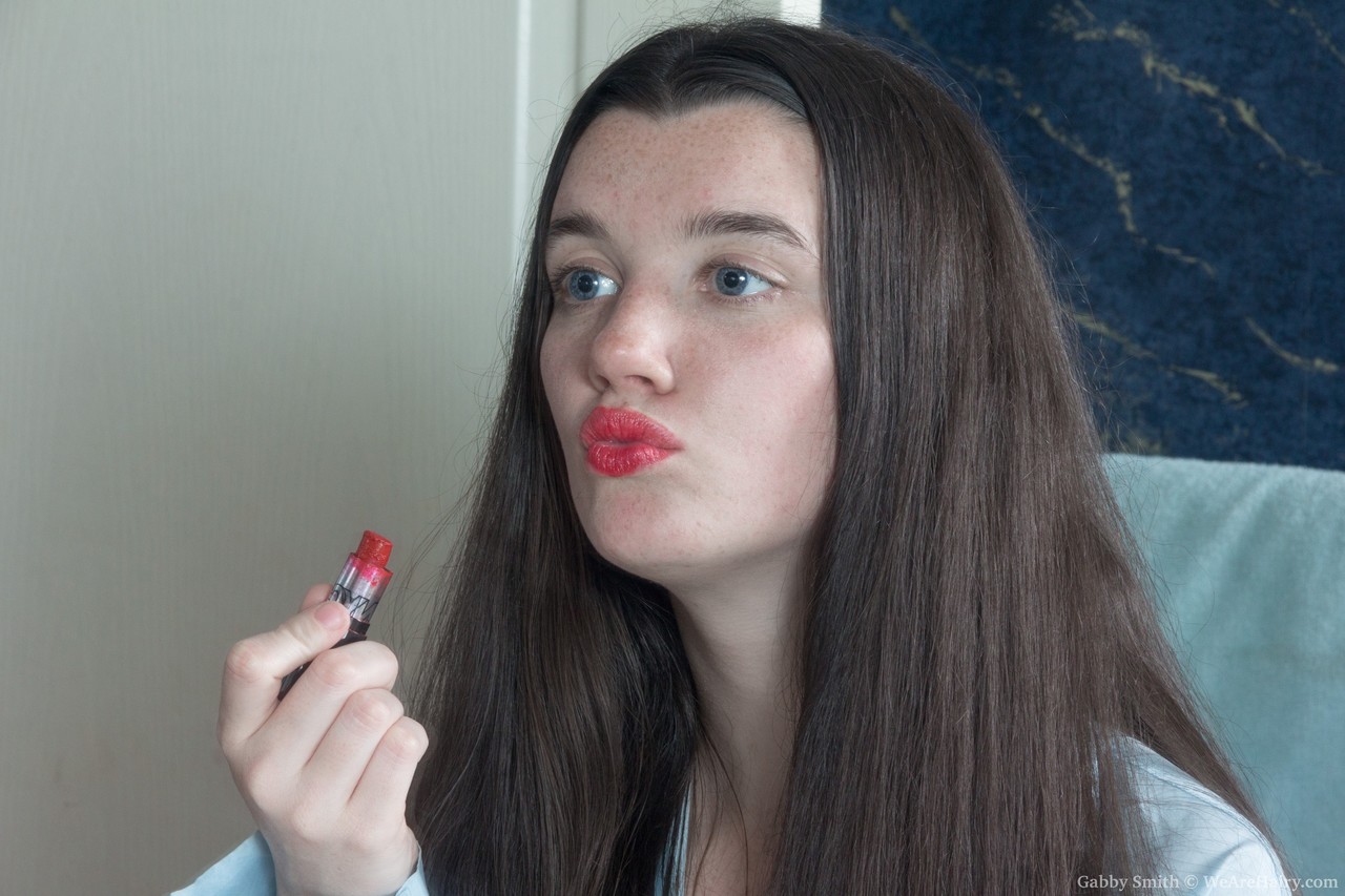 ガビースミス、ブラUNETの女性は赤い口紅をして、彼女の毛のあるヴァギナを準備しながら擦っている