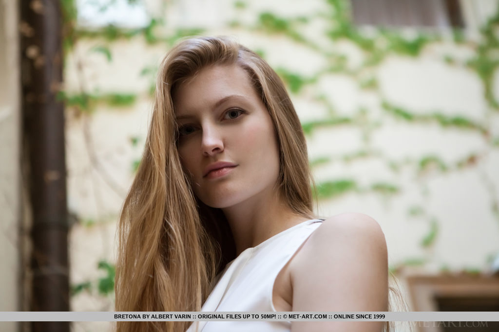 किशोर लड़की जिसके बाल गुंथे हुए हैं वह अपनी गीली योनि को नंगे पैर दिखाती है