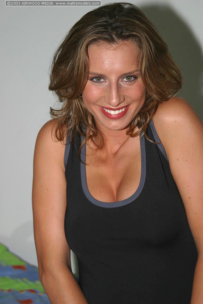 فتاة هاوية بثديين طبيعيين تتخذ أوضاعًا عارية على سرير فردي