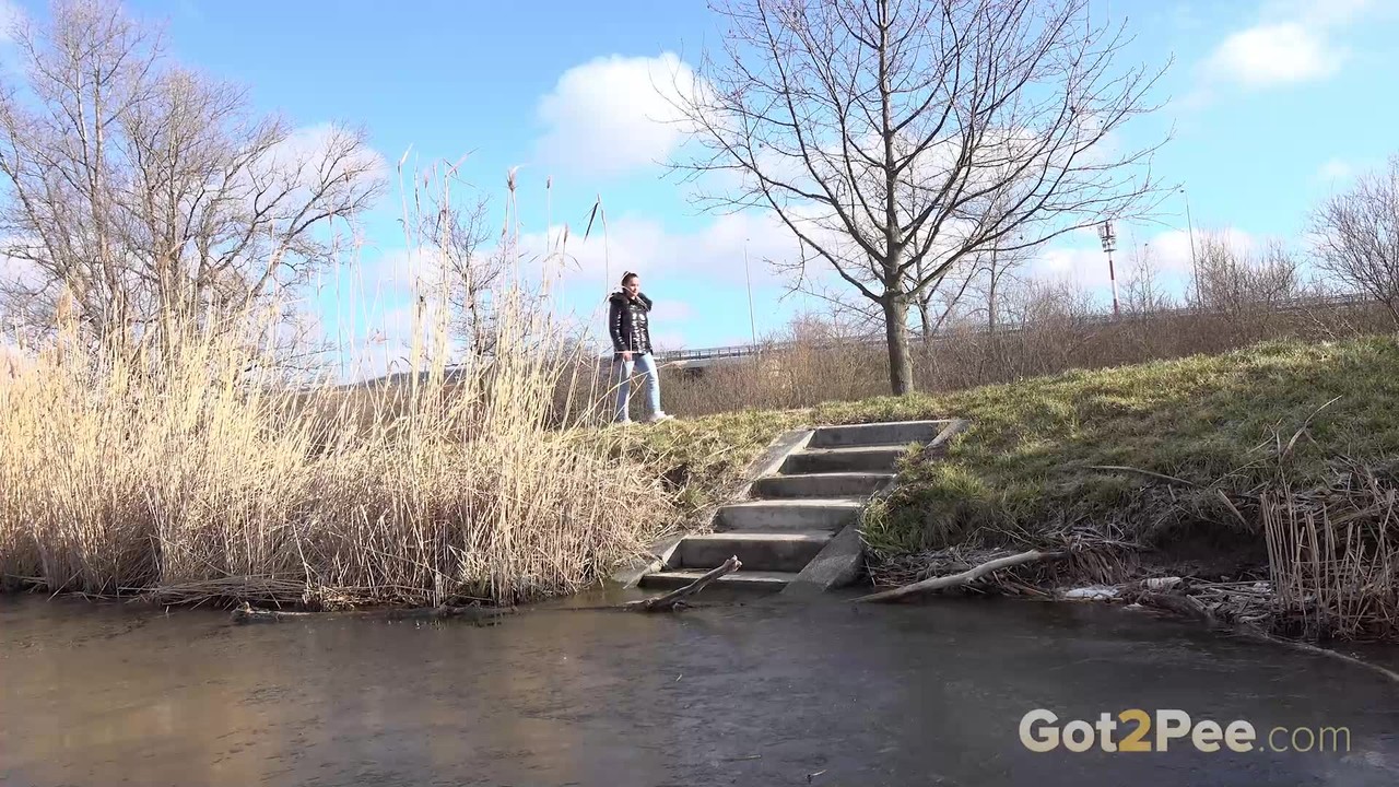 نعومي بينيت شعر بني تبول على درجات خرسانية بجانب الماء