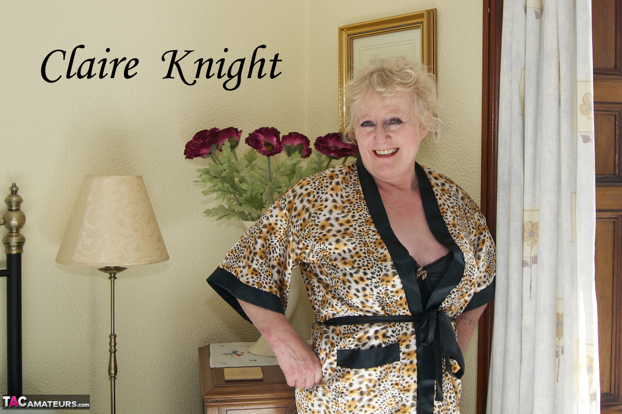 金髪の熟女がランジェリーとナイロンを身にまとい鏡の前で自分を眺める