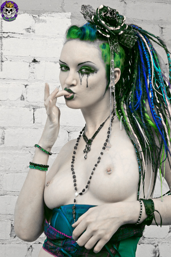 AltギャルScar 13がレンガの壁に胸を隠す