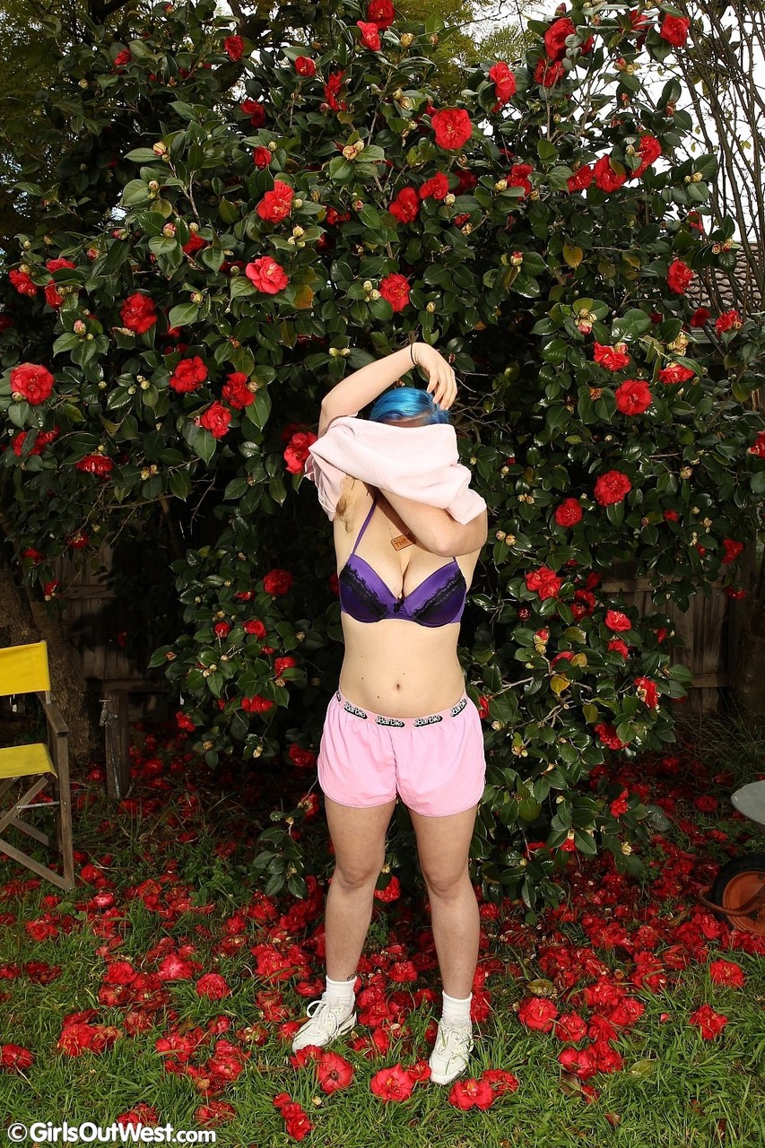 فتاة هواة شعرها أزرق تُظهر ثدييها ومؤخرتها الكبيرتين في الحديقة