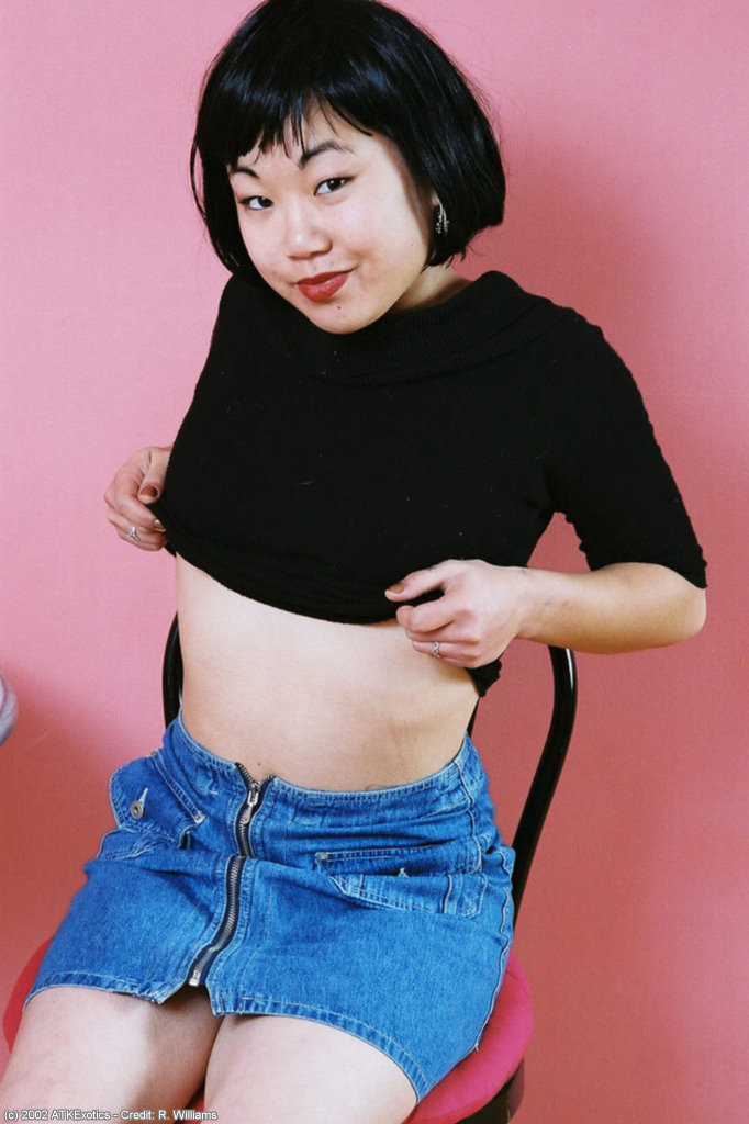 アジア人素人ジュンコがスカートを脱いで後、毛深いマンコの唇を広げる