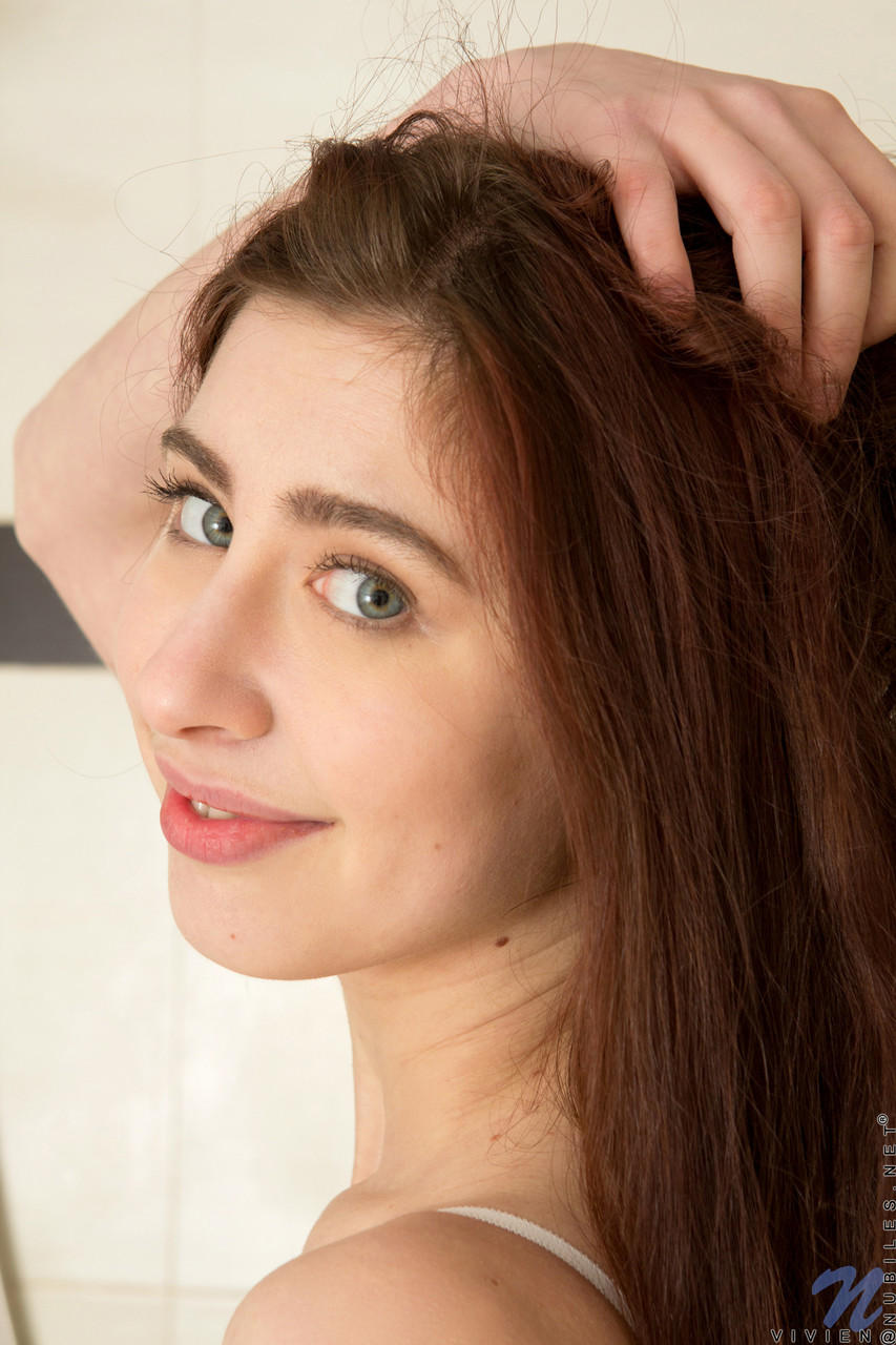 美しいティーンのビビアンは入浴中に彼女の誘惑的な剃毛マンコを誇示する