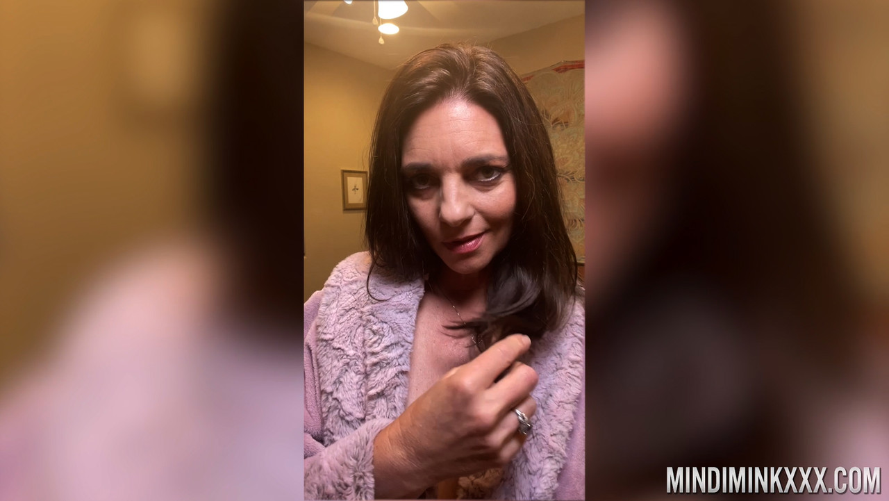 黒髪の人妻マインディ・ミンクが部屋で巨乳を披露しポーズを取る