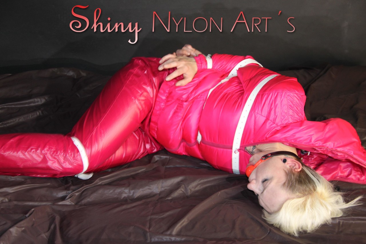 金发女郎被粉色羽绒服和雨衣裤捆绑并堵住嘴