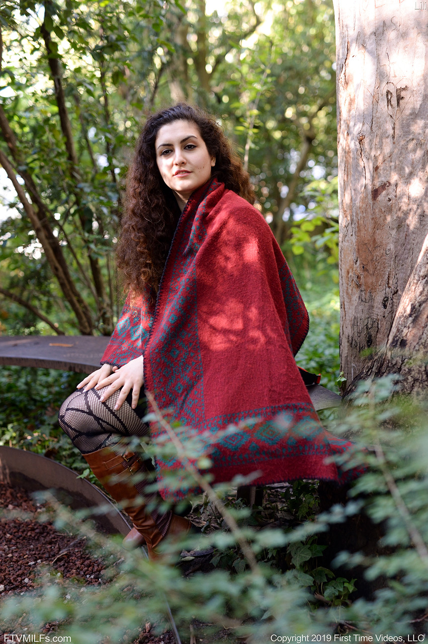 घुंघराले बालों वाली गोल-मटोल गुड़िया लिली प्रकृति में खुद से खेलती है