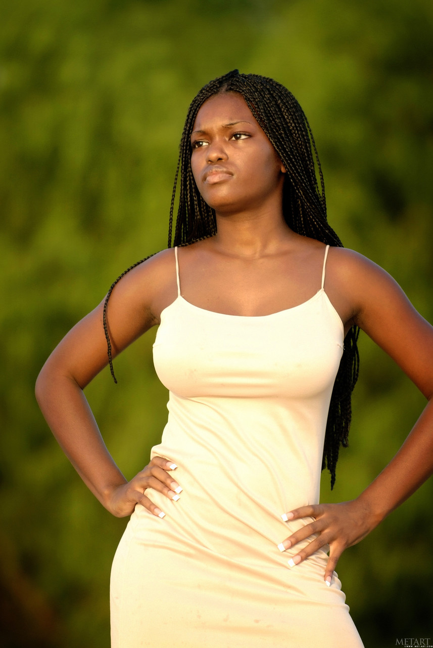 アフリカの美女デザリアAがジューシーな胸を披露しビーチでポーズを取る