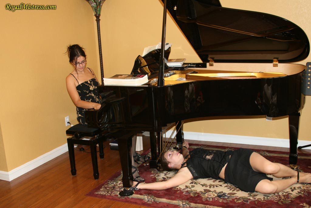 Brunette Pianist Plays While Restrained Woman Licks Her Heels