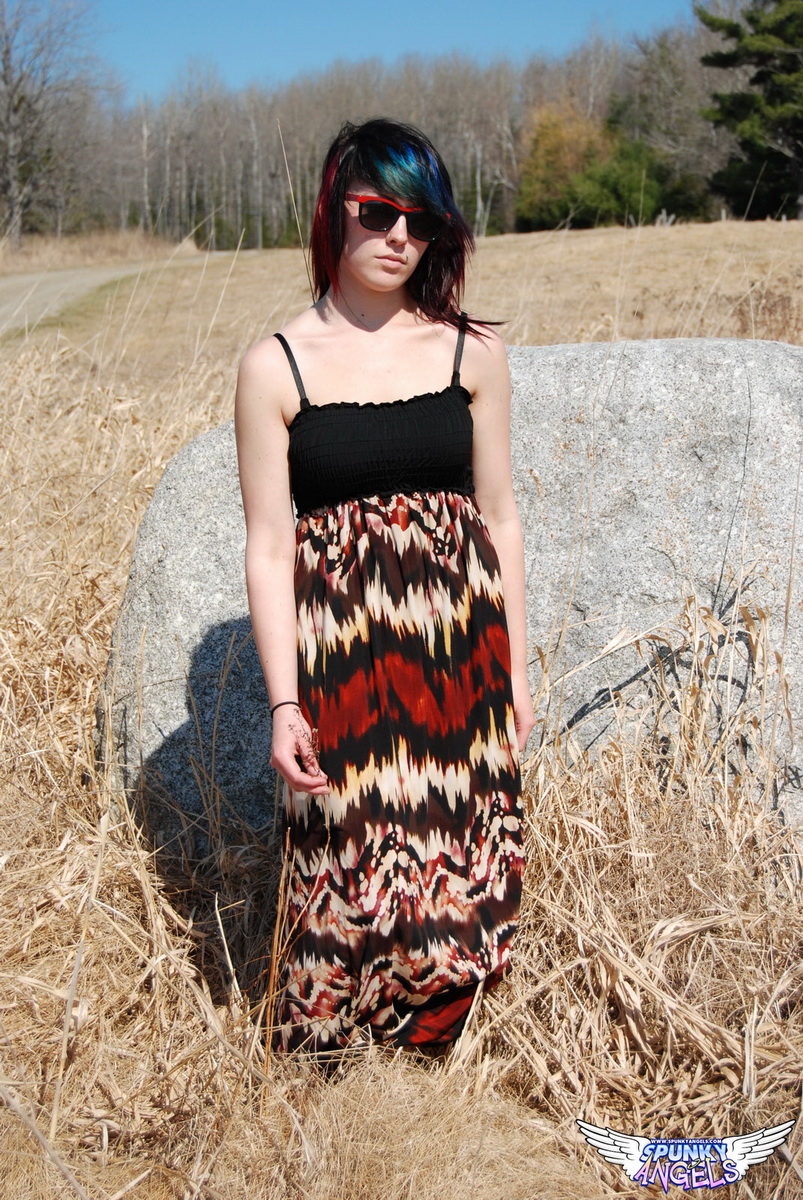 业余女孩萨布丽娜在田野里靠着巨石展现天然双乳